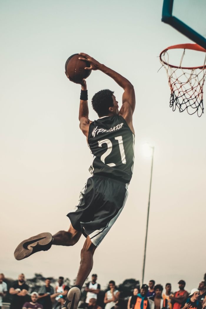 The Art of Drawing Readers In: Your attractive post title goes here A dynamic basketball player executing a slam dunk during a vibrant outdoor game.